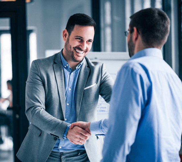 two-smiling-businessmen-shaking-hands